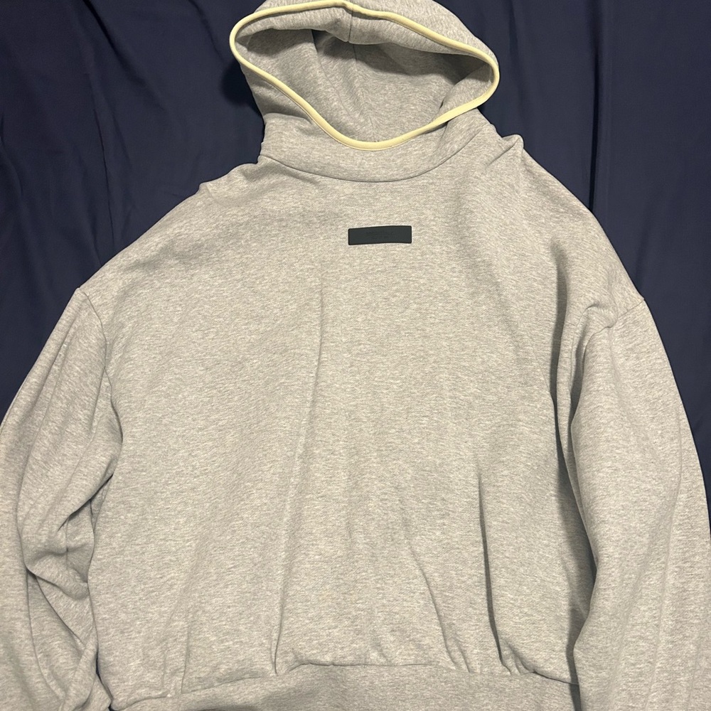 Gray essentials hoodie with yellow line on hood